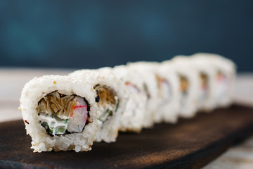 Tasty appetizing uramaki sushi rolls with crab meat, covered with sesame seeds, close up. Restaurant menu
