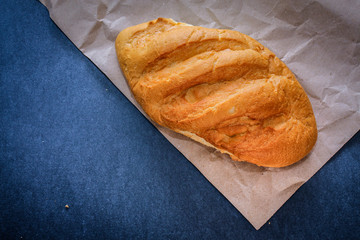 bread on the table just from the stove. Freshly baked bread on kraft paper on a dark background.
