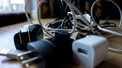 Black and white different cables usb chargers and wires tangled and in chaos