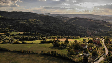 Fototapeta premium Aerial view of beautiful autumn sunset with a lot of clouds. Amazing colors and shadows of the clouds on the land. Landscape of village in Sumadija near the Kragujevac.