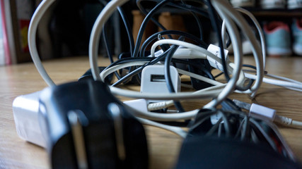 Black and white different cables usb chargers and wires tangled and in chaos