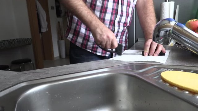The man is sharpening a kitchen knife