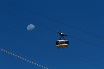 Sugarloaf mountain cable car full of tourists with crescent moon background (Rio de Janeiro, Brazil)