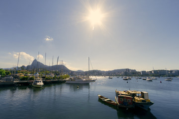 Fototapeta premium Two fishing boats moored next to sailboats and yachts in the Guanabara Bay (Rio de Janeiro, Brazil) with Christ the Redeemer statue in the background