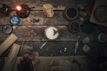 Magic potion preparation on the table of magician. Witchcraft or druidism concept background.