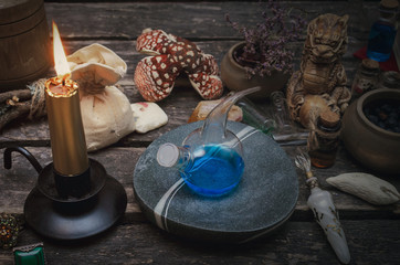 Magic potion preparation on the table of magician. Witchcraft or druidism concept background.