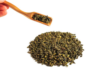 Chinese green teguanin tea, scattered on a white background, poured with a tea spatula and a tea filter.