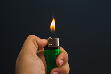 Close-up view of a hand holding burning gas lighter.