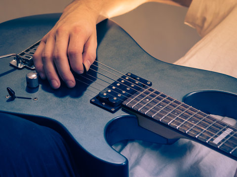 Close up of man playing on electric guitar