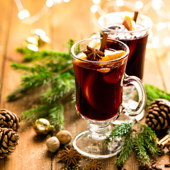 Christmas mulled red wine with spices and oranges on a wooden rustic table. Traditional hot drink at Christmas