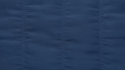 warm blue dark jacket fabric texture background close-up.