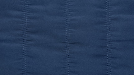 warm blue dark jacket fabric texture background close-up. © Konstantin