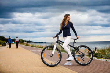 Young woman and bike at seaside