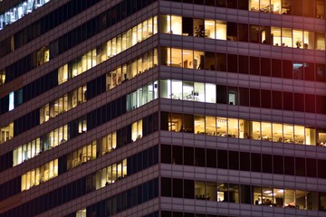 Obraz premium Office building at night. Late night at work. Glass curtain wall office building