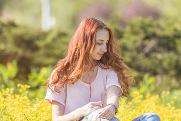 Young girl on a lawn field with yellow flowers