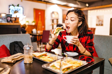 Beautiful freelancer businesswoman eating her lunch in coffee shop