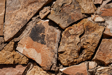 Part texture background made of natural stone, large pieces, yellow brown.