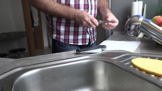 The man is sharpening a kitchen knife