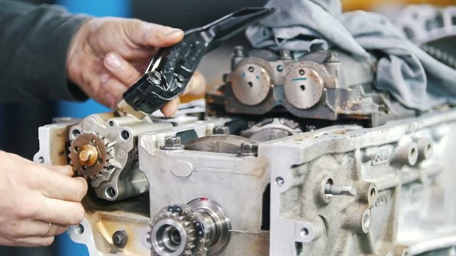 The mechanic's hands check the operability of the parts in the car
