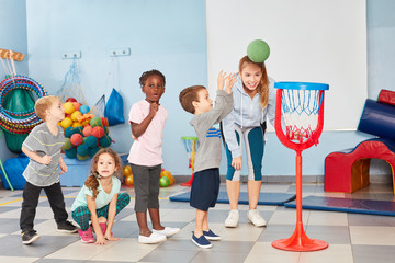 Kinder werfen Basketball in ein Netz
