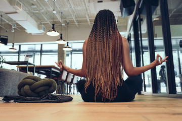 Rear view of a woman doing yoga pose indoors