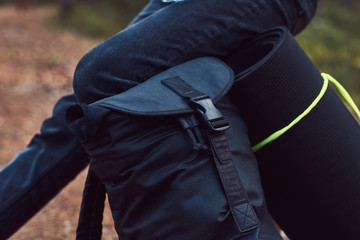 Tourist concept. Cropped photo of a girl who stopped for rest in autumn forest.