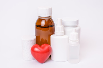 Cure remedy dose pattern template place for text myocardial infarction ischemia concept. Close up photo of many bottled plastic containers with tablets drugs small heart isolated on background