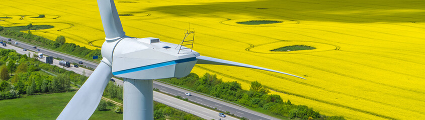 Windkraftanlage an Autobahn und gelbem Rapsfeld Panorama ökostrom
