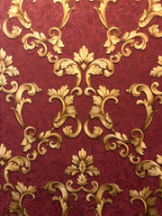 Golden monograms on a dark red background. Texture, surface, background decor.Beautiful pattern,...
