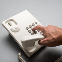 Male hand dialing telephone number