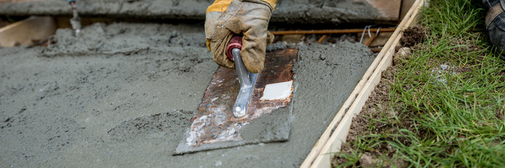 Closeup of gloved hand smoothing concrete surface