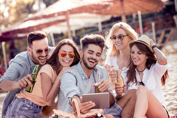 Group of friends taking a selfie with tablet ,having fun