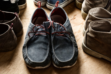 pile of men's shoes on wooden table