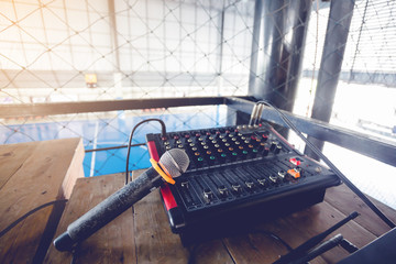 Microphone and audio mixer controller for football field with net in stadium.