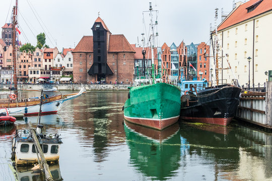 Gdansk cityscape. Poland principal seaport which is located at the mouth of the Motlawa River.  Boats and architecture  with the historical crane on the embankment.