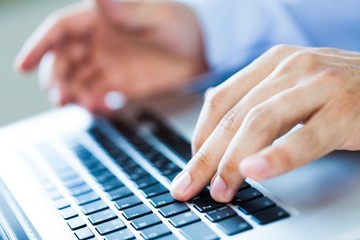 Fototapeta na wymiar Closeup of a Businessman Typing on a Laptop