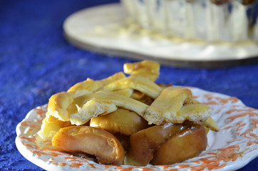 Whole apple pie, top view, a piece is taken out with a chrome cake server