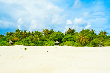 Beautiful sandy beach with sunbeds and umbrellas in Indian ocean, Maldives island