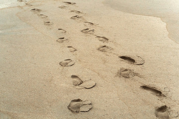The trail of two people. Footprints of people on the sand.