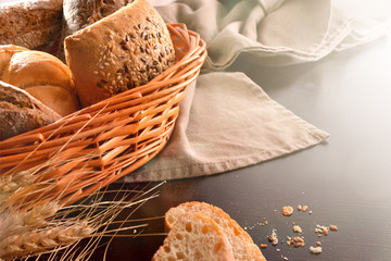 Basket with bread on fabric and black wooden table