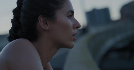 young hispanic woman runner resting exhausted after intense running exercise in city at sunrise training cardio workout enjoying fitness lifestyle close up