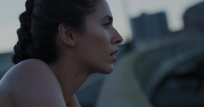 young hispanic woman runner resting exhausted after intense running exercise in city at sunrise training cardio workout enjoying fitness lifestyle close up