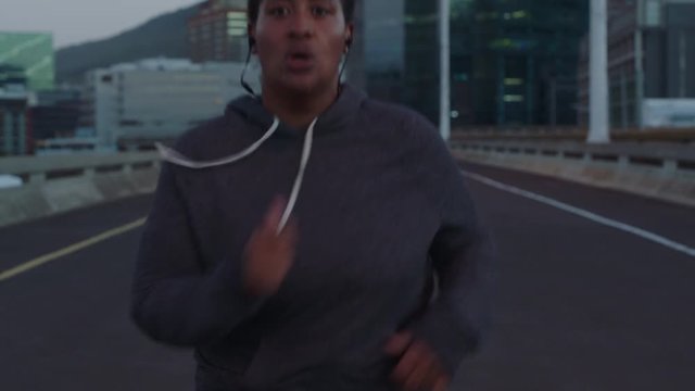 overweight african american woman runner resting exhausted after difficult running cardio exercise tired black female in urban city at sunset