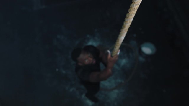 healthy man athlete rope climbing training intense workout muscular bodybuilder doing strength exercise enjoying fitness lifestyle in gym top view slow motion