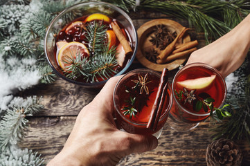 hands holding glasses with mulled wine for Christmas and festive period