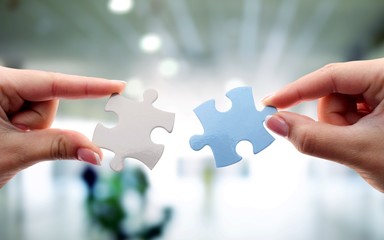 Hands of woman and man holding puzzles