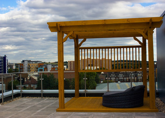 wooden gazebo made of wood on the roof with an armchair
