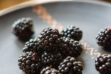 large juicy blackberry berries on a ceramic plate