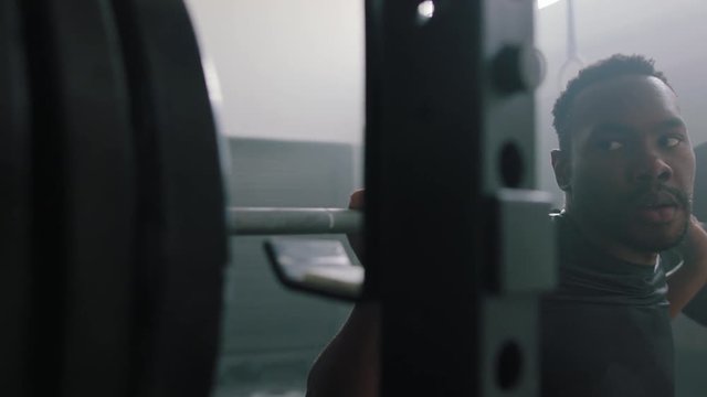 fitness man bodybuilder training using barbell weightlifting exercise muscular sportsman power lifting heavy weight doing squats  in gym practice enjoying healthy lifestyle