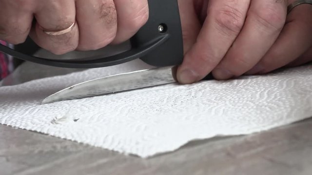 The man is sharpening a kitchen knife